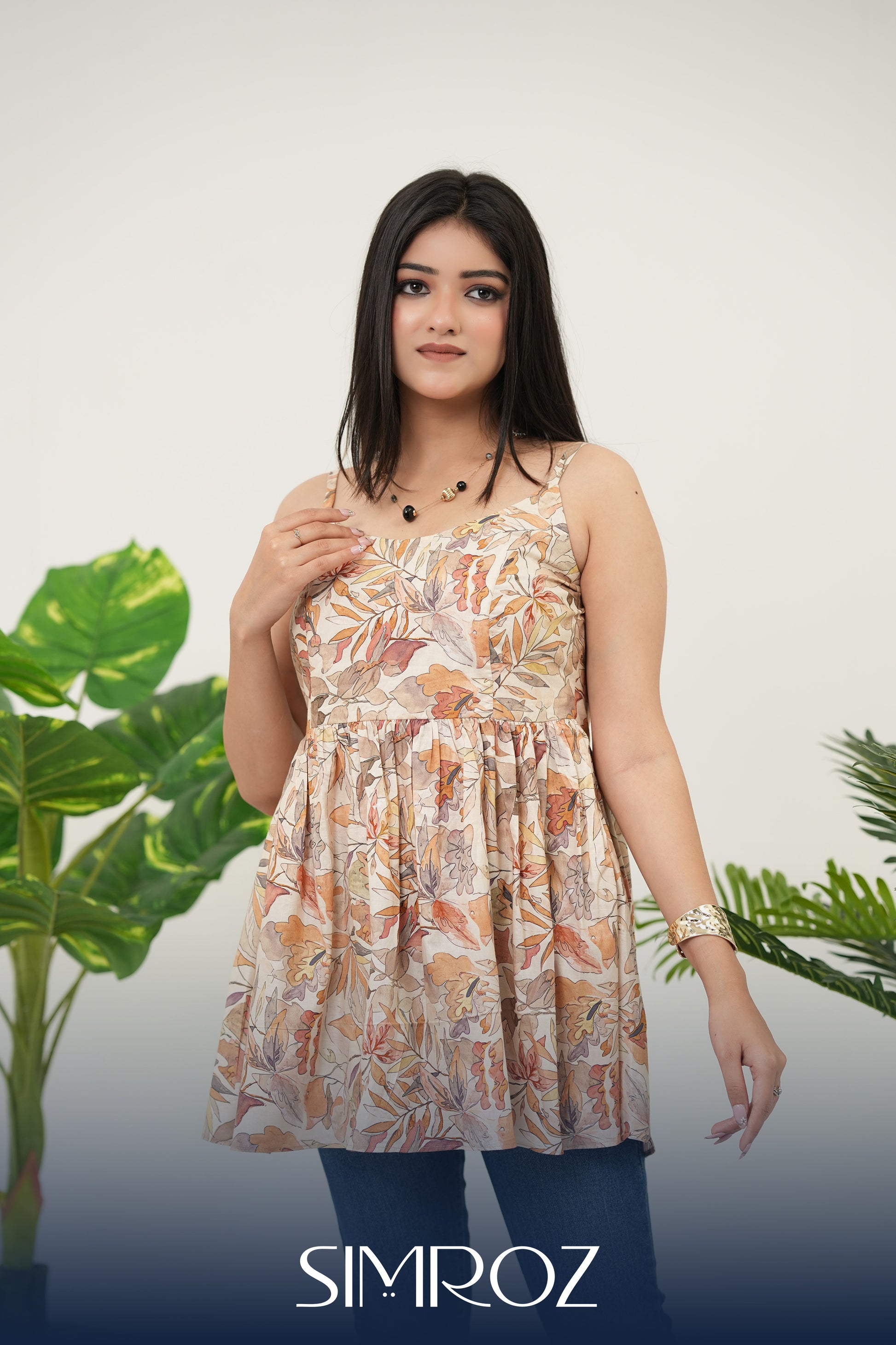 Front view of Autumn Whispers Sleeveless Top for women in beige cotton cambric fabric, featuring gathered style, sleeveless design, delicate digital autumn leaf print, and a chic standing pose for a stylish summer look - Simroz.