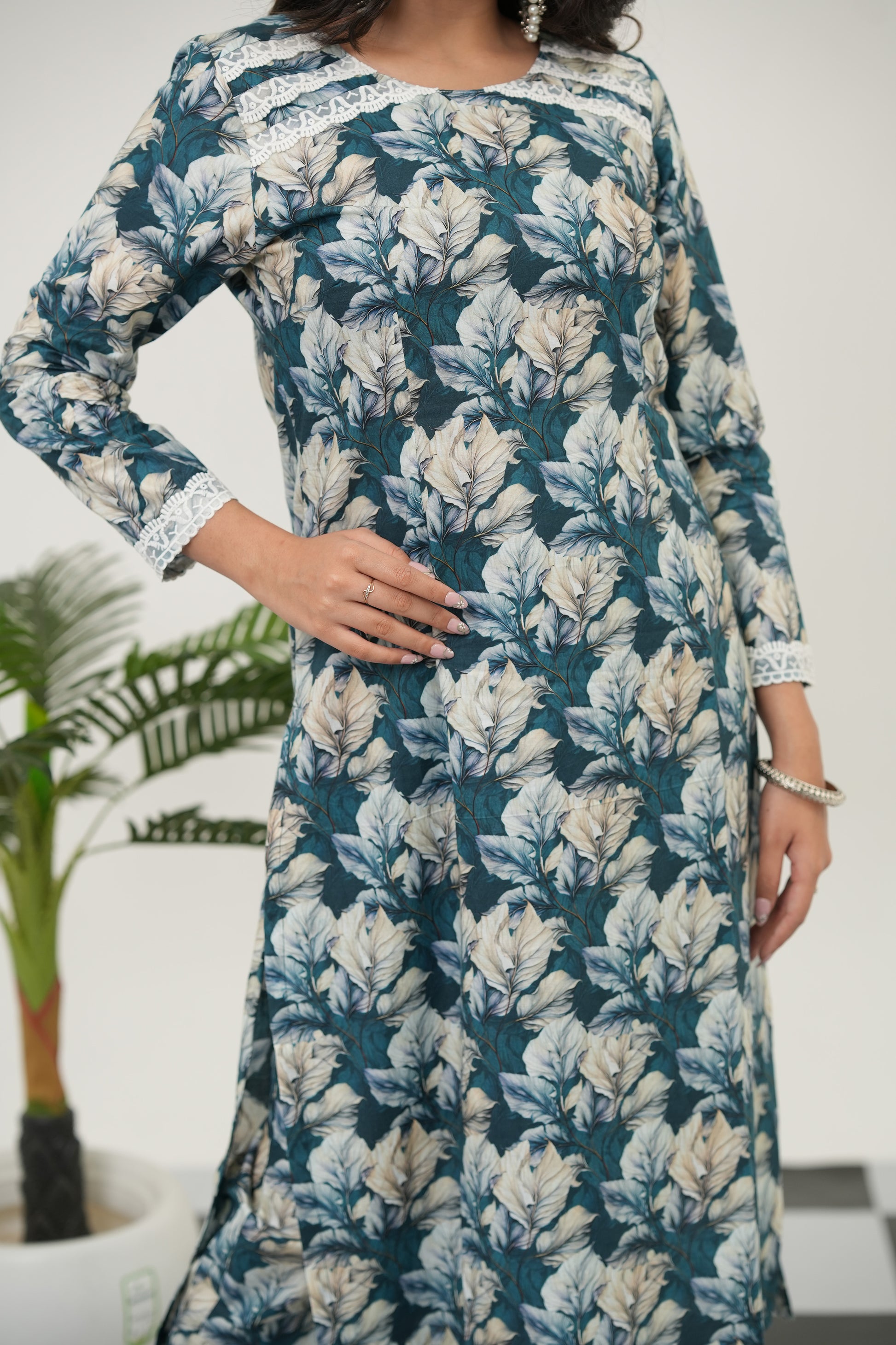 A woman standing in SIMROZ Verdant Bloom digital print kurta set for women, featuring vibrant botanical prints on soft blue cotton fabric, straight style design, 3/4 sleeve pattern, and elegant summer wear.