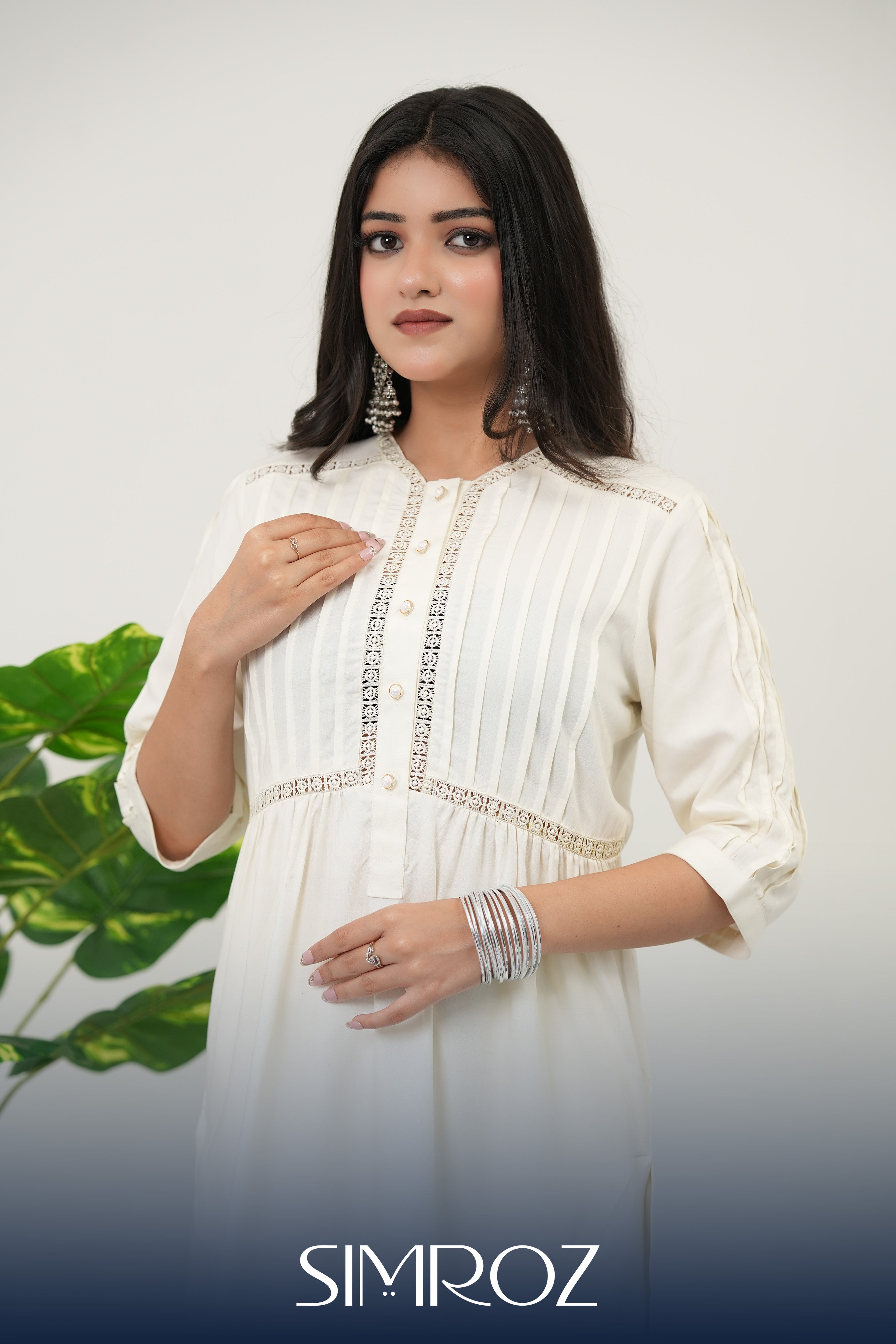 Summer Snow off-white kurta set with pintuck detailing, intricate lace work, and shimmering mirror accents by SIMROZ