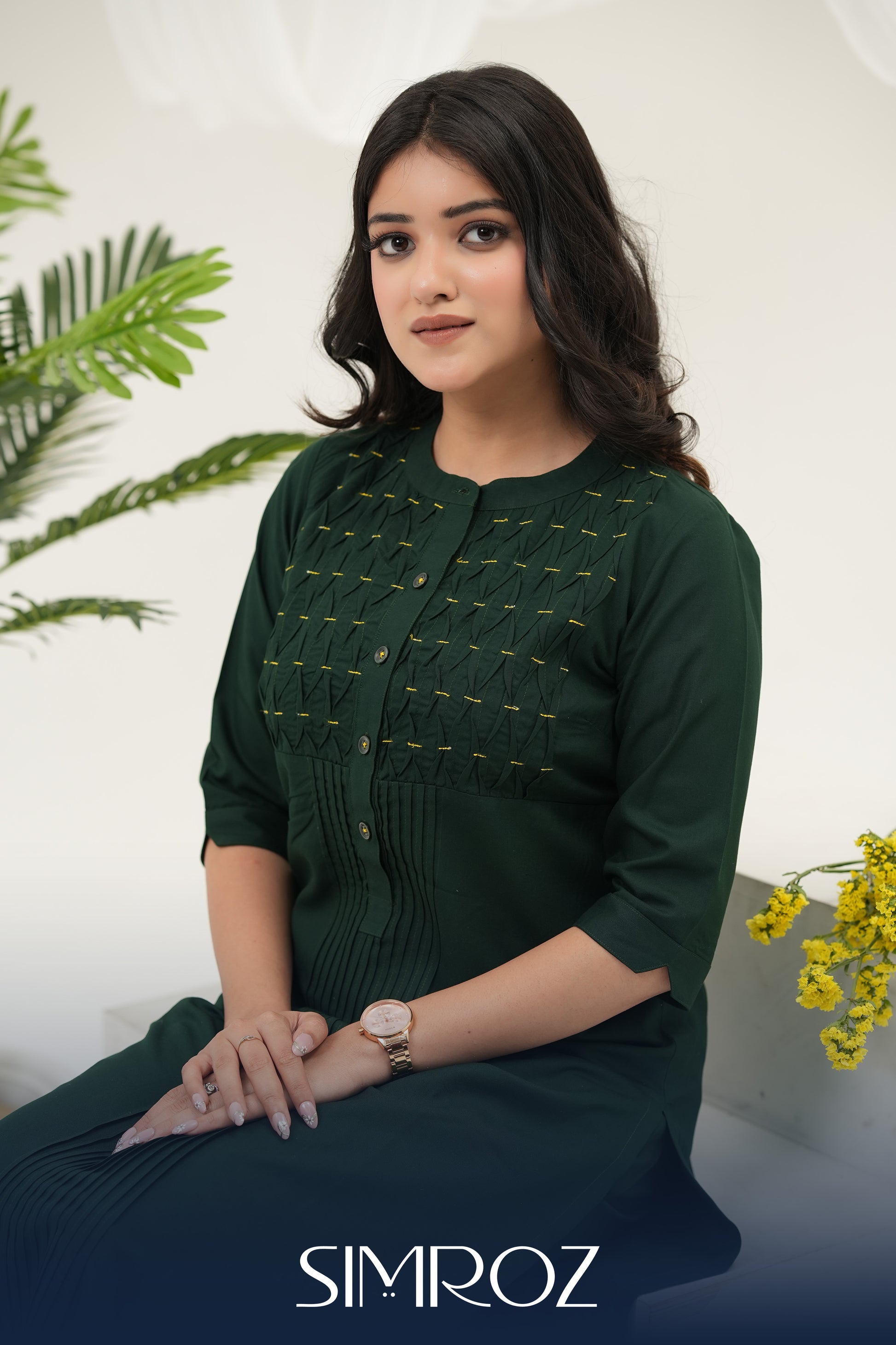A woman sitting against a white background with Emerald Weave kurta set by SIMROZ featuring intricate woven yoke design, delicate beads handwork, and soft rayon viscose fabric.