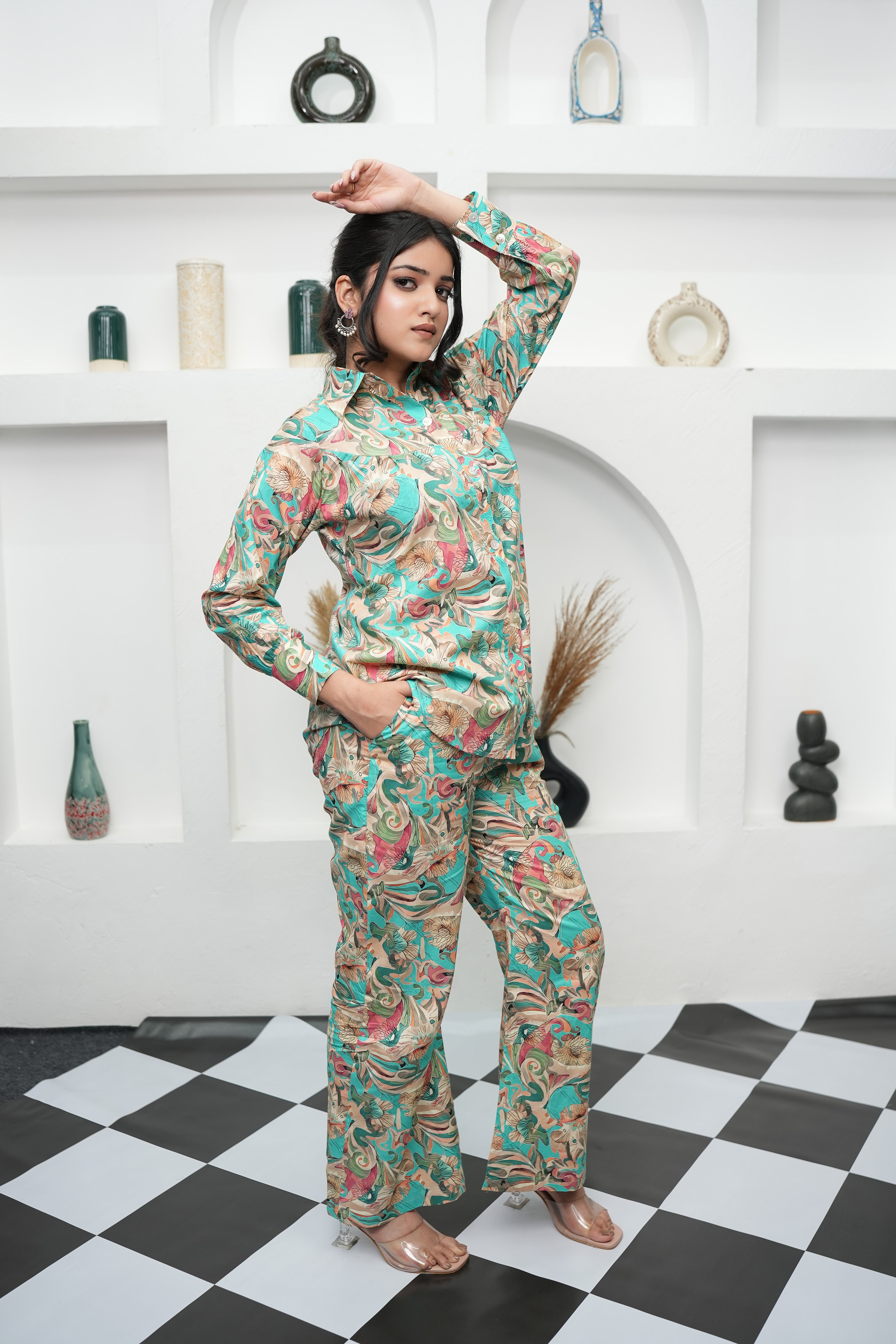 A woman is standing, full view, wearing a teal and beige printed co-ord set with a floral pattern - Simroz.