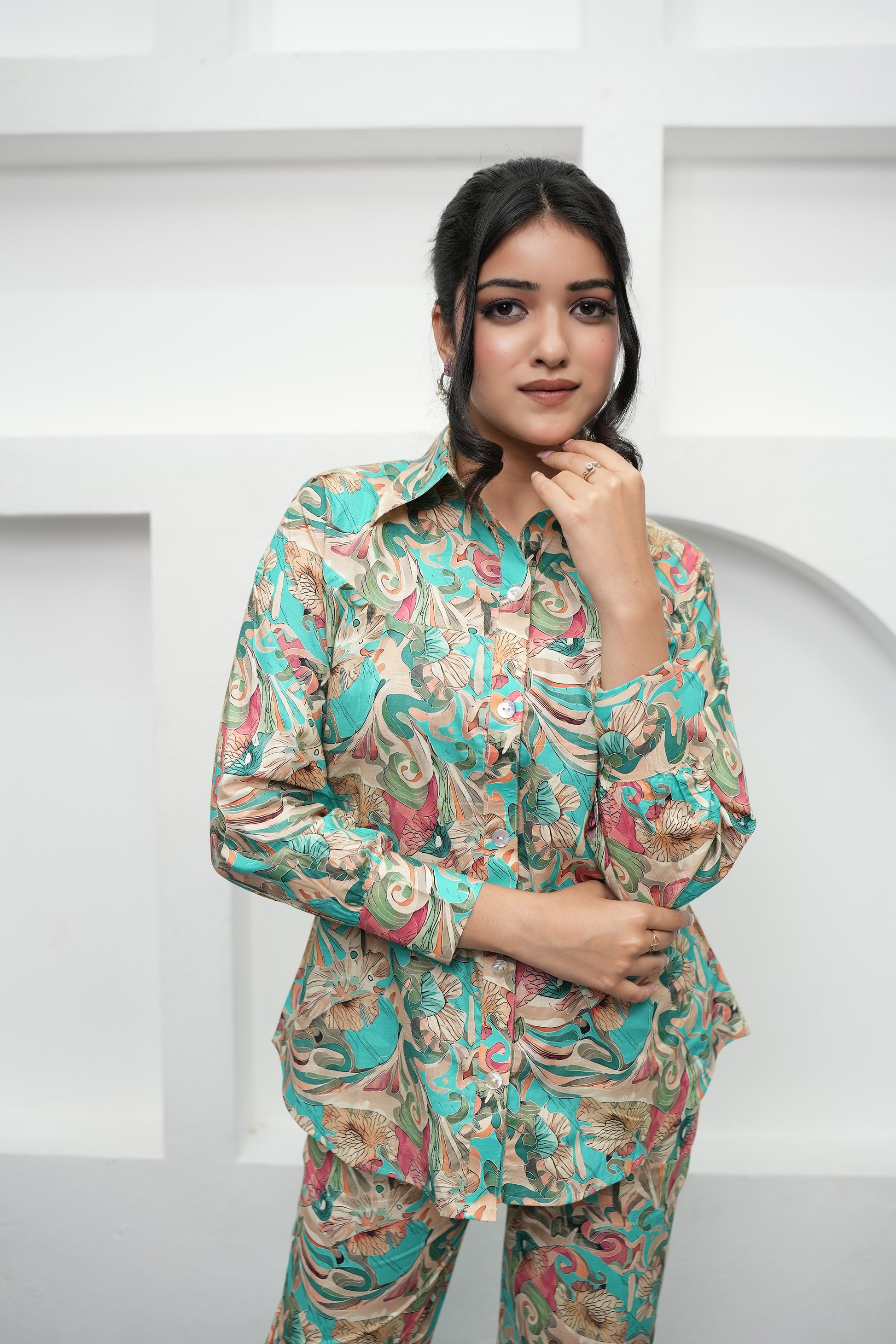 A woman is standing, posing, wearing a teal and beige printed co-ord set with a floral pattern - Simroz.