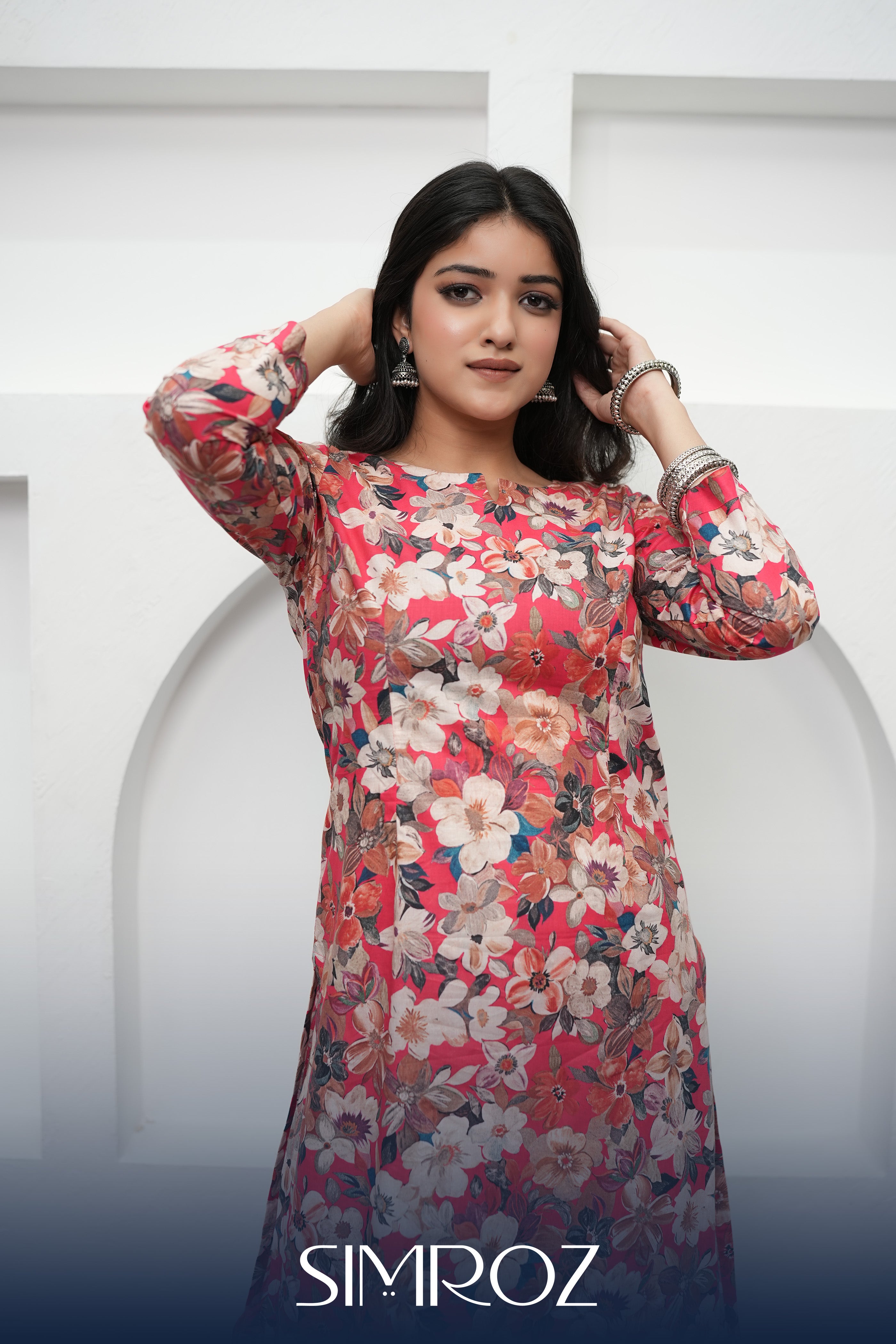 A woman posing in a Scarlet Bloom digital print kurta set with vibrant floral patterns and breathable cotton cambric fabric by SIMROZ