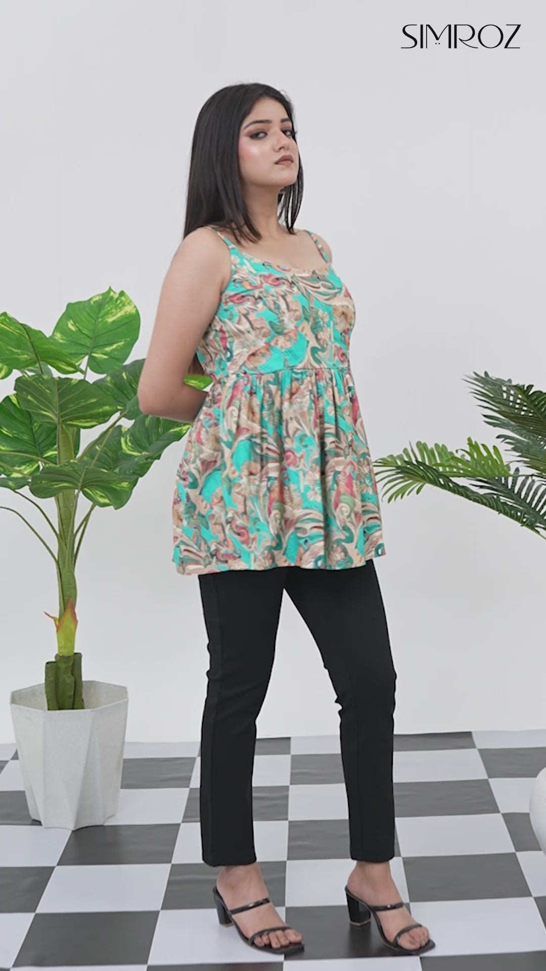 Load video: Short video clip of a model posing in Aqua Breeze Tie-Shoulder Top for women, teal blue cotton cambric fabric, gathered sleeveless style, vibrant tropical digital print, captured from multiple camera angles for a chic summer look - Simroz.
