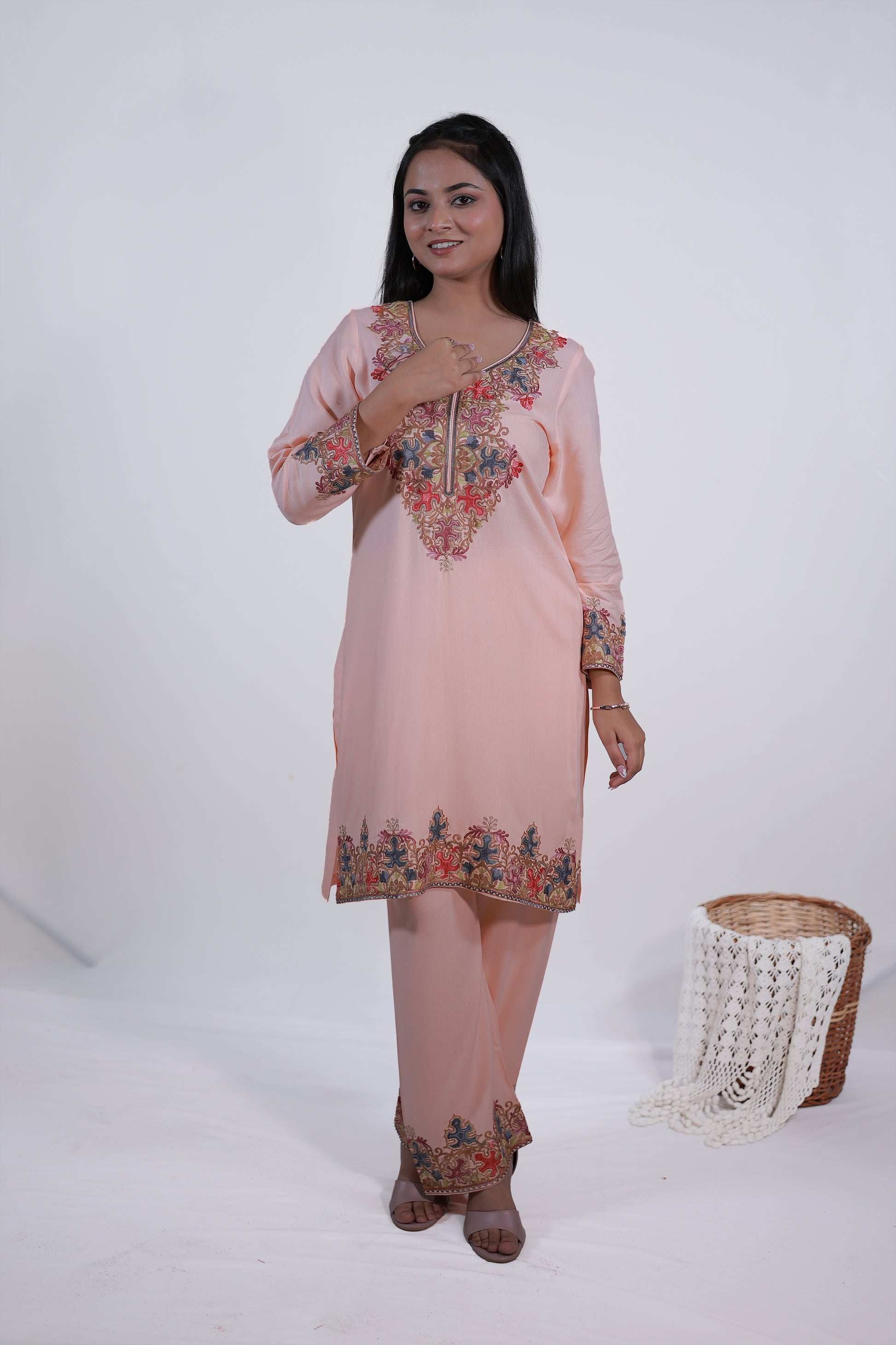 A model standing in peach orange Kashmiri embroidered Gul-e-Kashmir Kurta Set by Simroz, festive ethnic outfit for women