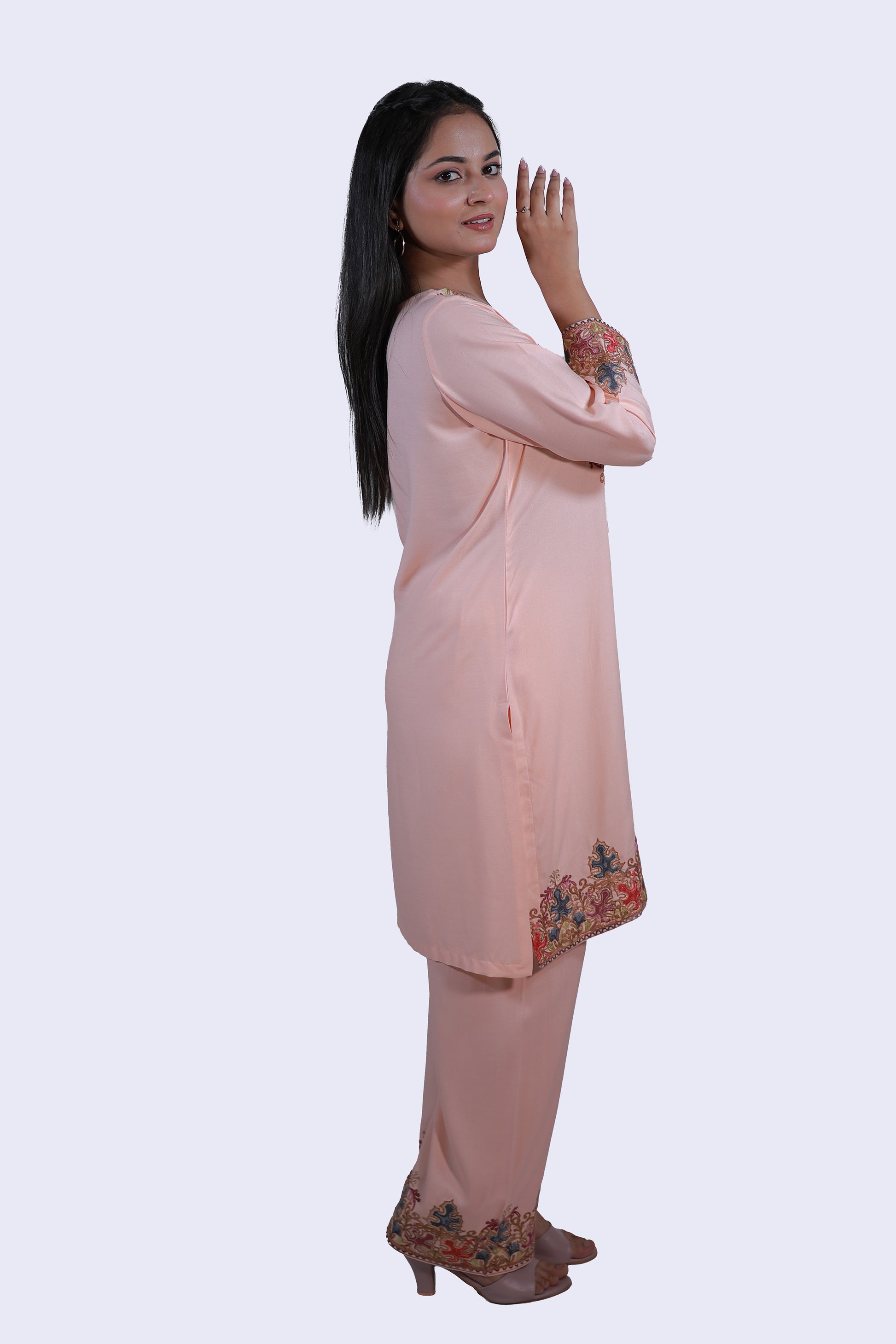Side pose of model wearing Simroz peach orange Kashmiri Aari embroidered Kurta Set, rayon viscose straight-fit design