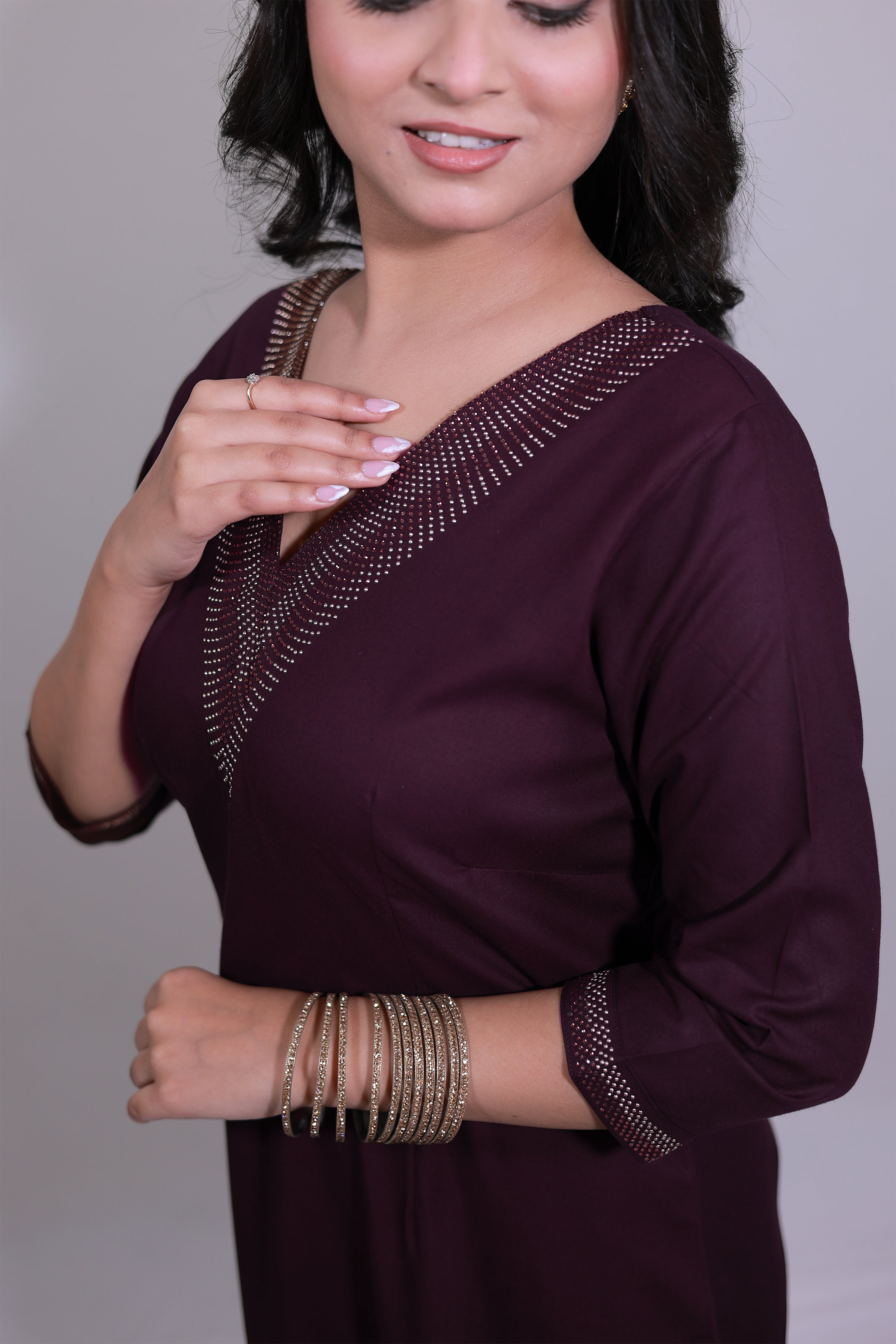 Woman wearing Elegant wine kurta set featuring Swarovski detailing on neckline and sleeves - Simroz.