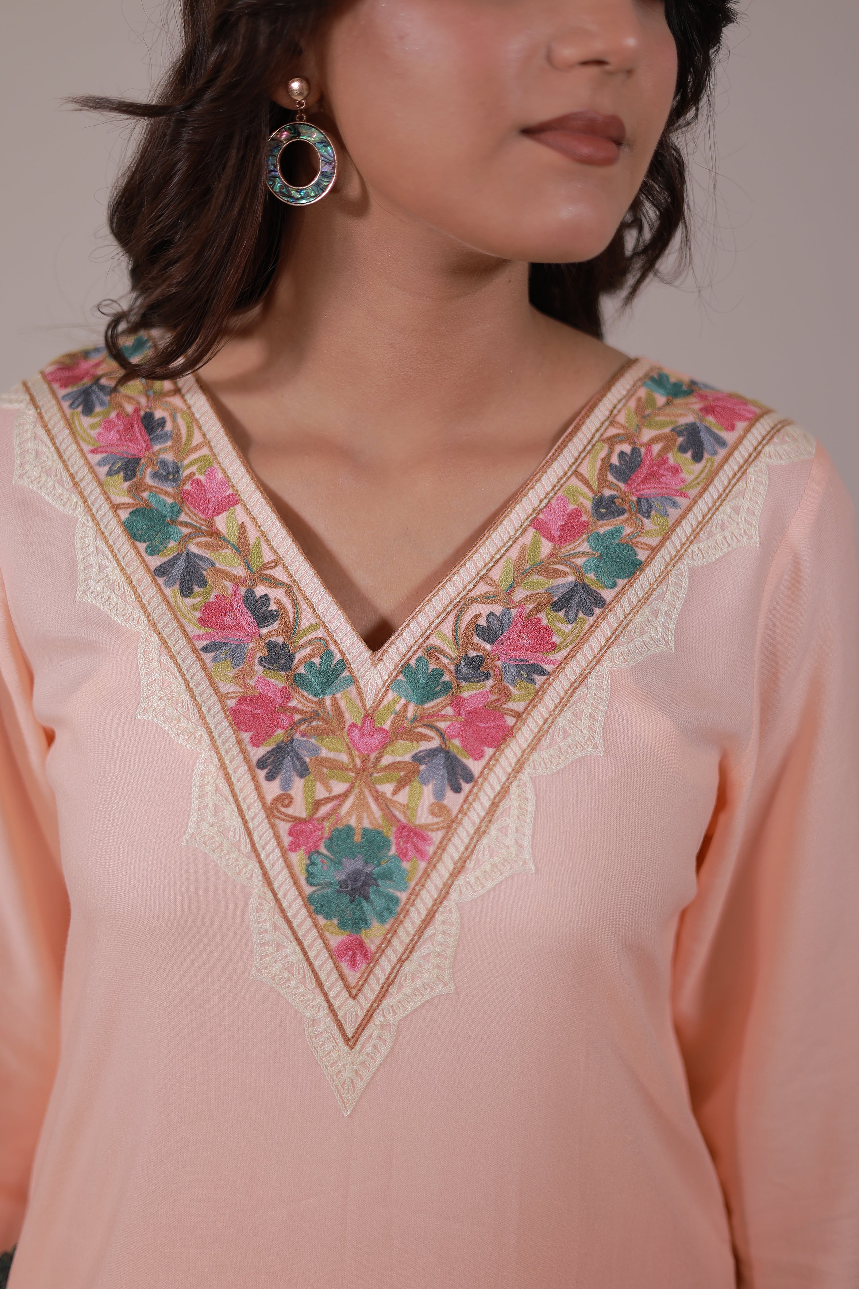 A woman wearing Simroz Bahaar-e-Gulmarg Kurta Set, Kashmiri Aari embroidery, Peach Orange – front neck view